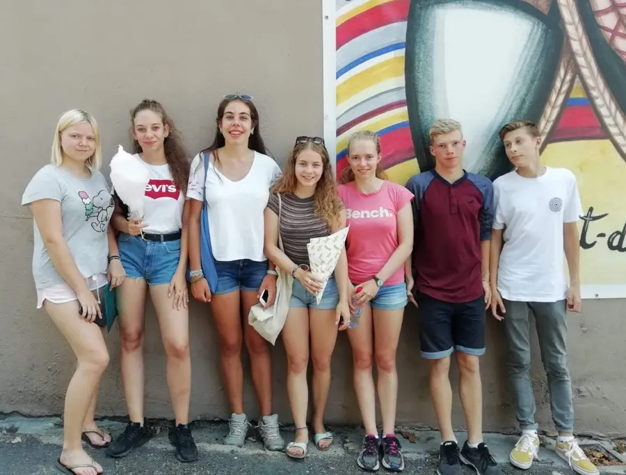 Cinco jóvenes sonrientes posando delante de un muro, en el pueblo de Saint-Laurent-de-Cerdans