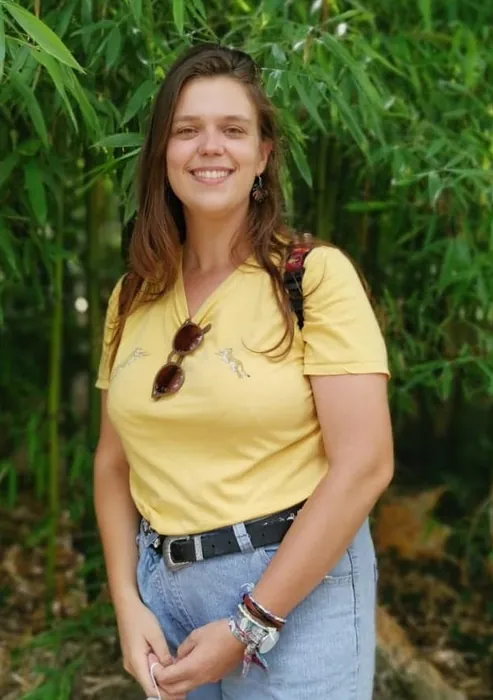 Portrait d’Amelia, l’adjointe administrative, pédagogique et commerciale de FIL, souriante, devant des bambous