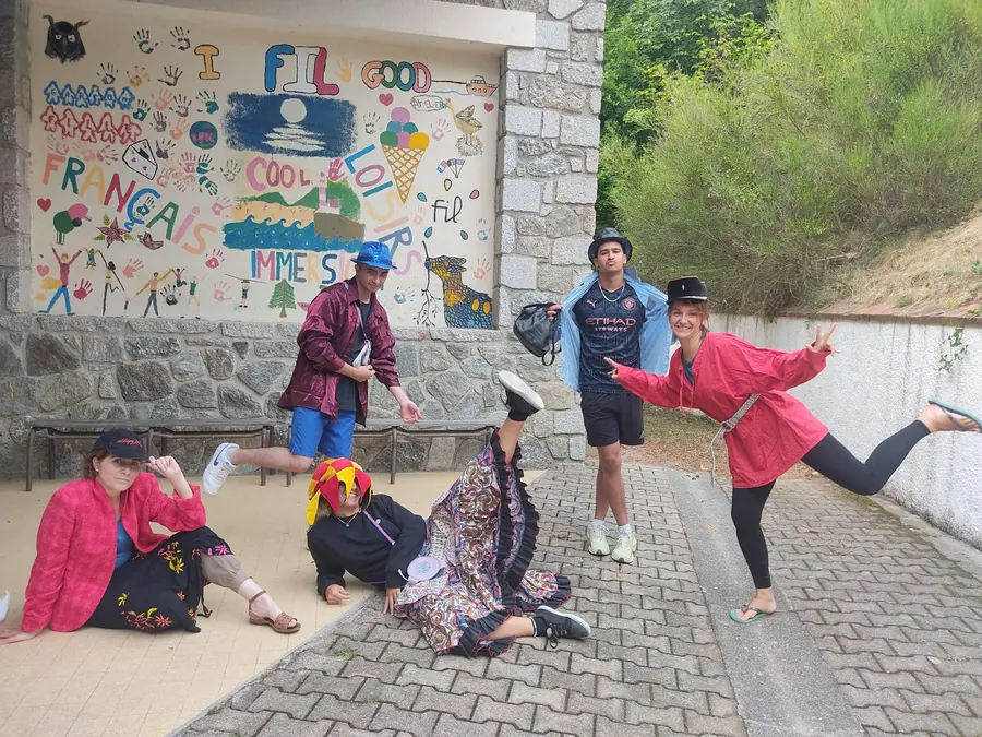 Des animateurs déguisés qui mettent en scène une saynète devant une fresque colorée sur un mur