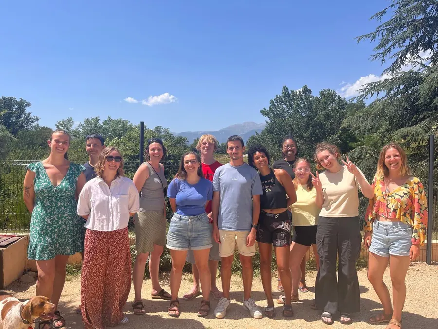 L’équipe d’animation de FIL en 2024 : une douzaine de jeunes adultes posant ensemble, en plein soleil, devant des arbres et la montagne