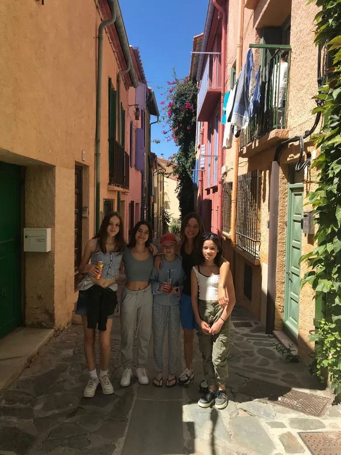 Cinq jeunes qui posent dans une ruelle colorée d’un village de la côte