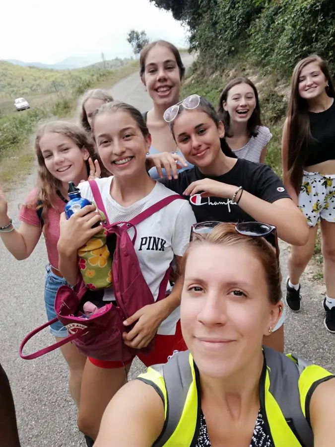 Un selfi de clase: alumnos y su acompañante con chaleco amarillo, en un sendero de montaña
