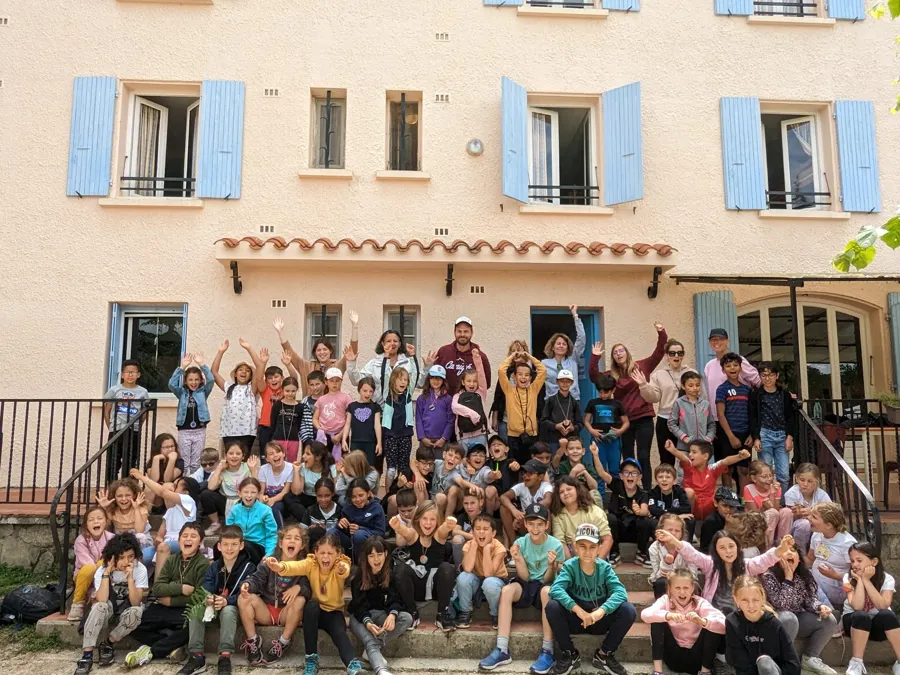 Todo el grupo de alumnos reunido delante de la fachada del Domaine Le Noell, con los brazos en alto