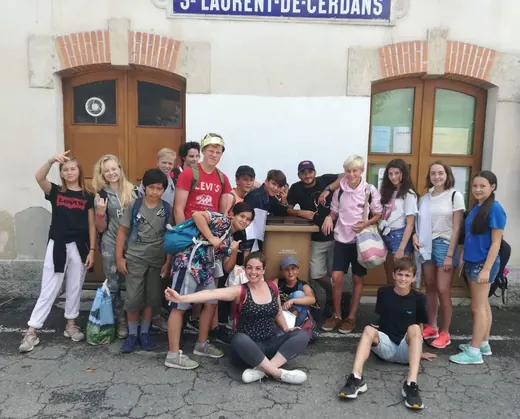 Un groupe de jeunes posant devant le bâtiment de la gare de Saint-Laurent-de-Cerdans