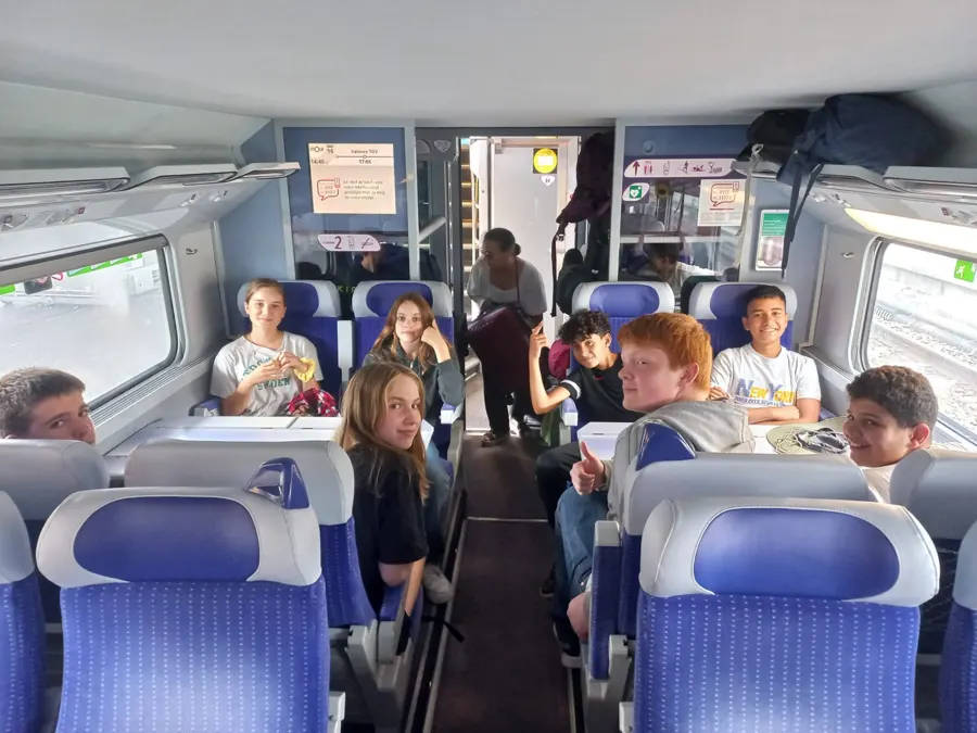 Des jeunes qui voyagent ensemble dans un train, assis face à face